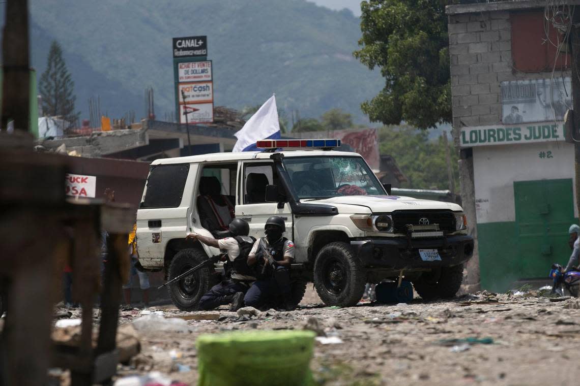 Police officers hide as protesters throw rocks at them during a protest demanding the resignation of Haitian Prime Minister Ariel Henry and a call for a better quality of life in Port-au-Prince, Haiti, Wednesday, September 7, 2022 (AP Photo/Odelyn Joseph)